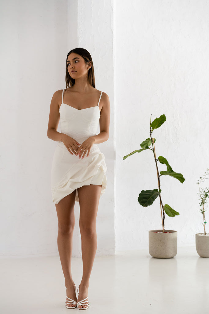 The Maddox Dress is an asymmetrical little white dress. 